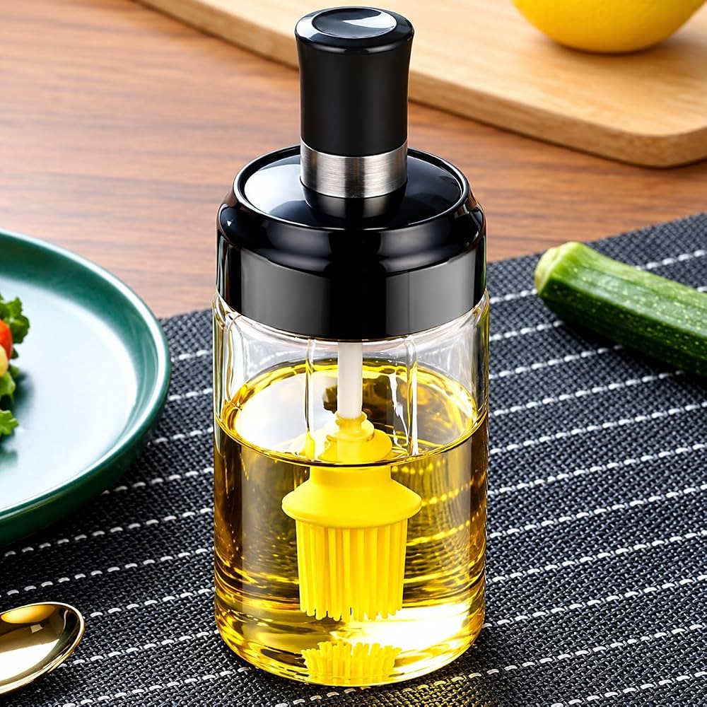 Glass oil dispenser bottle with yellow silicone brush on kitchen table
