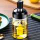Glass oil dispenser bottle with yellow silicone brush on kitchen table